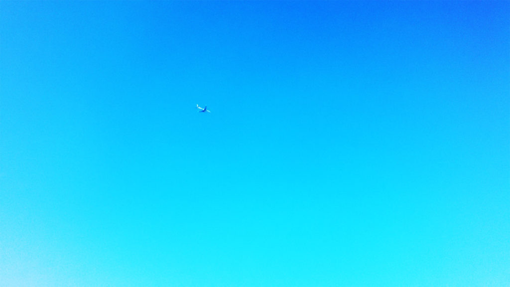 雲一つない空を飛ぶ飛行機