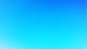 雲一つない空を飛ぶ飛行機